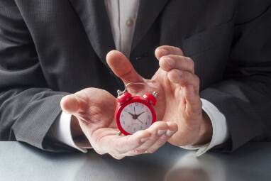 business man holding a small clock
